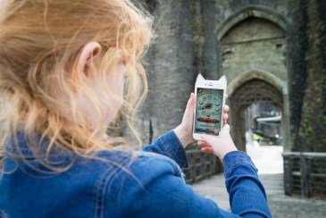 Ymwelwr yn defnyddio'r gem dal dreigiau